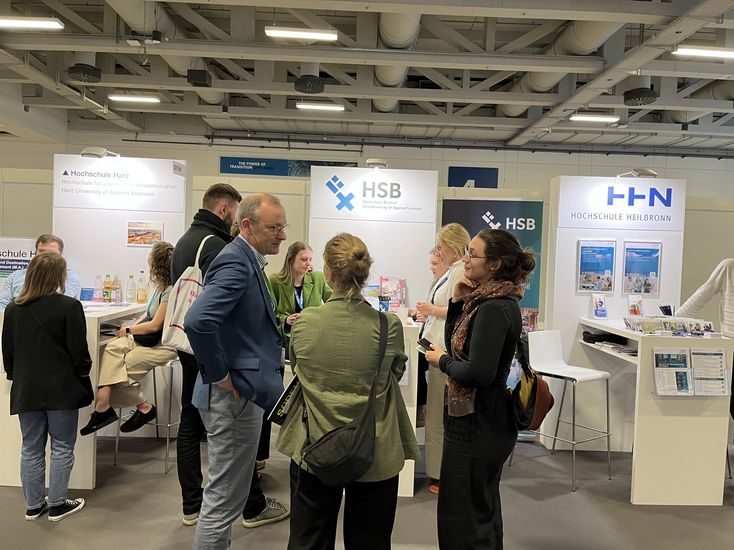 Auf dem Bild stehen Gr&uuml;ppchen von Leuten, die sich unterhalten. Im Hintergrund ist der HSB Messestand zusehen. 