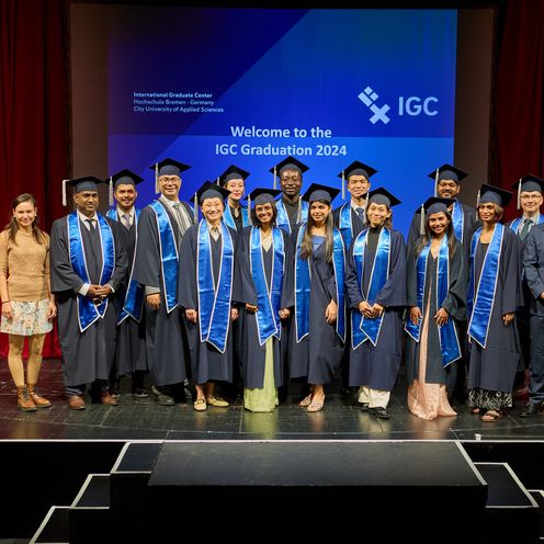 Gruppenbild mit M&auml;nnern und Frauen. Sie tragen Talare und H&uuml;te.