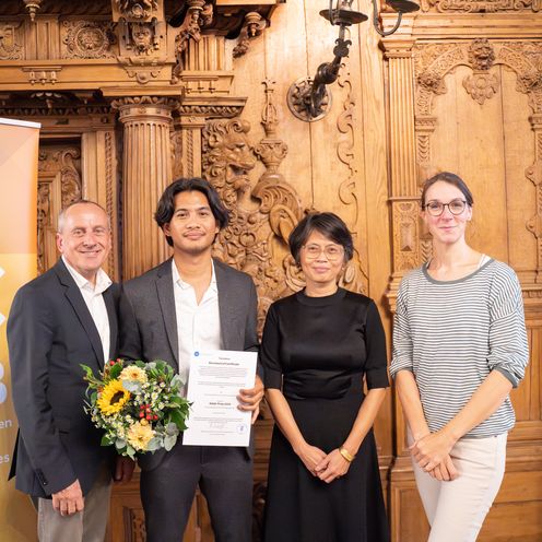 Auf dem Foto stehen vier Personen und blicken in die Kamera