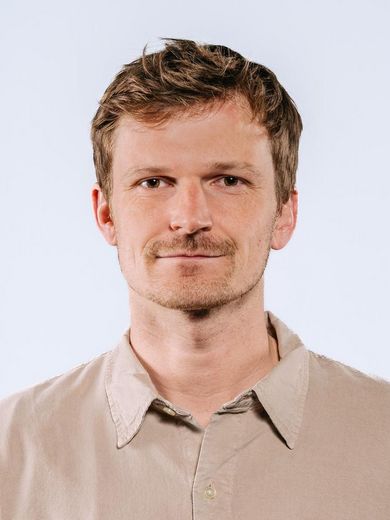 Auf dem Foto ist Matthis Gericke zusehen. Er hat kurzes braunes Haar und einen Drei-Tage-Bart. Er trägt ein Braunes Hemd. 