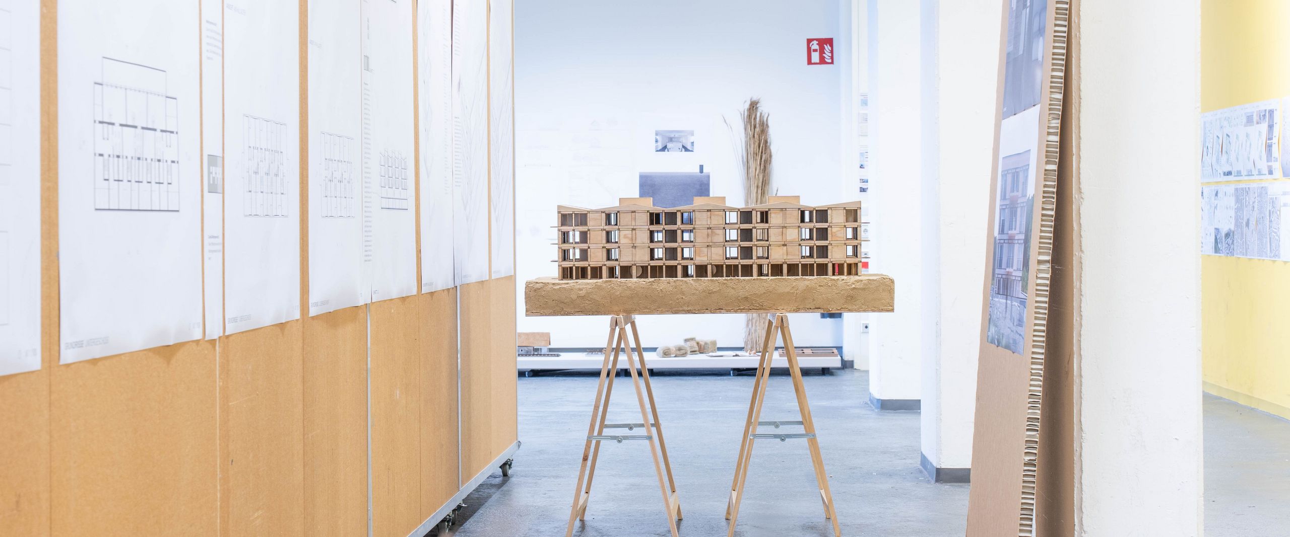 Architektonische Modelle und Pläne sind in einem Flur ausgestellt und aufgegangen. 