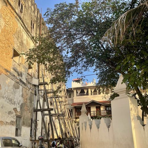 Steinhäuser, die zum Teil von Holzpfählen gestützt werden 