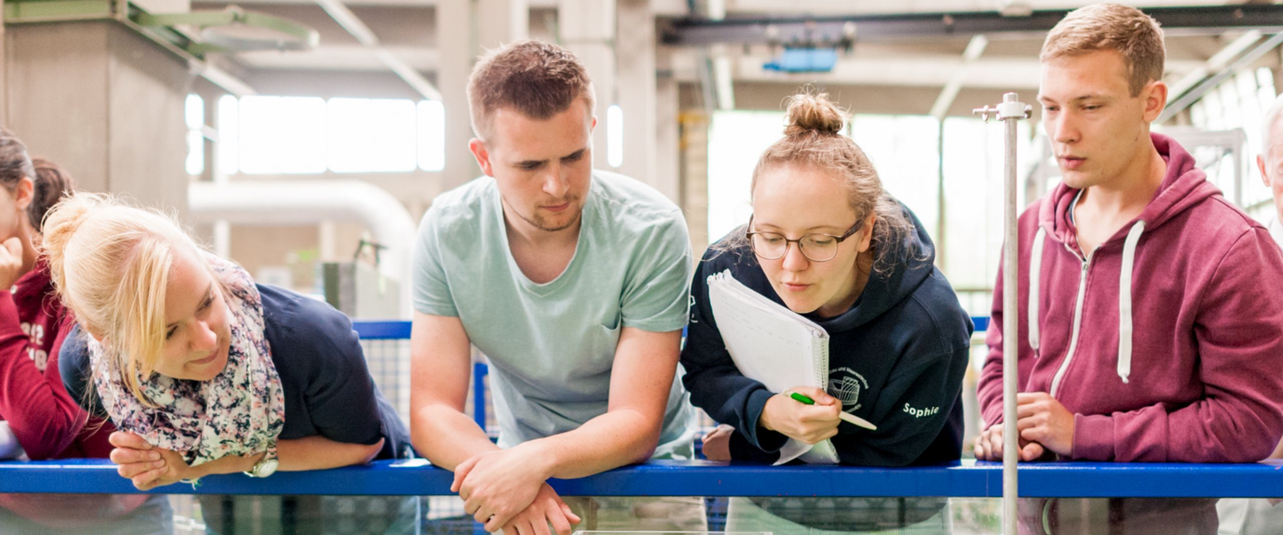 Studierende testen eine schwimmende Konstruktion in einem Wasserbecken.