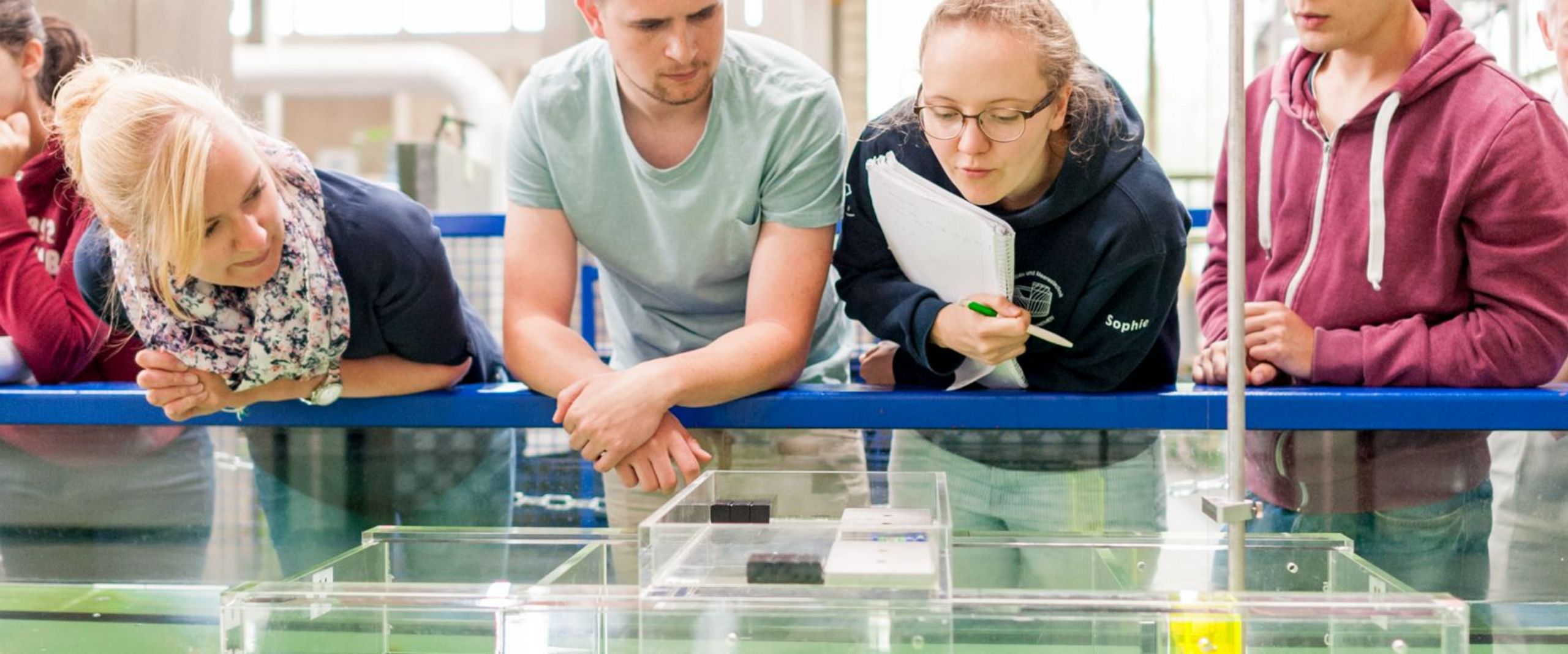 Studierende testen eine schwimmende Konstruktion in einem Wasserbecken.