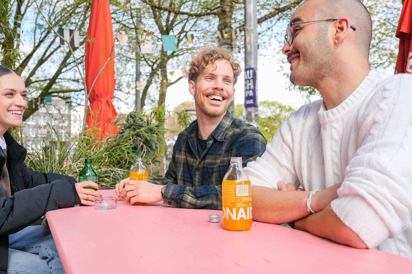 Studierendenleben Auf dem Bild sitzt eine Frau und zwei Männer an einer Bierzeltgarnitur und trinken Softdrinks.