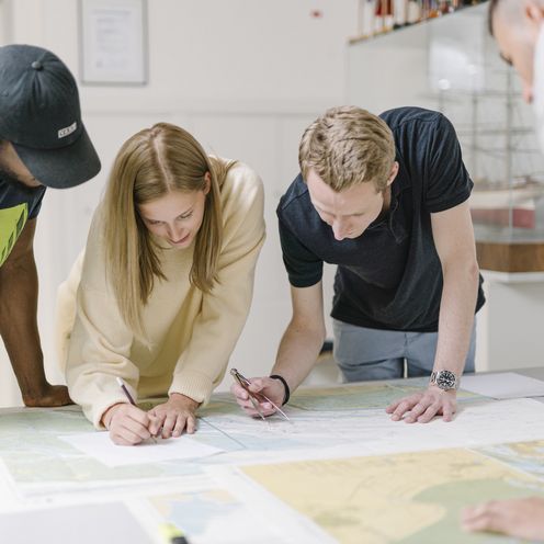 Nautikstudierende arbeiten mit Seekarten.