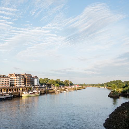 Blick auf das Weserufer mit zwei anliegenden Schiffen: das Theaterschiff und die MS Treue