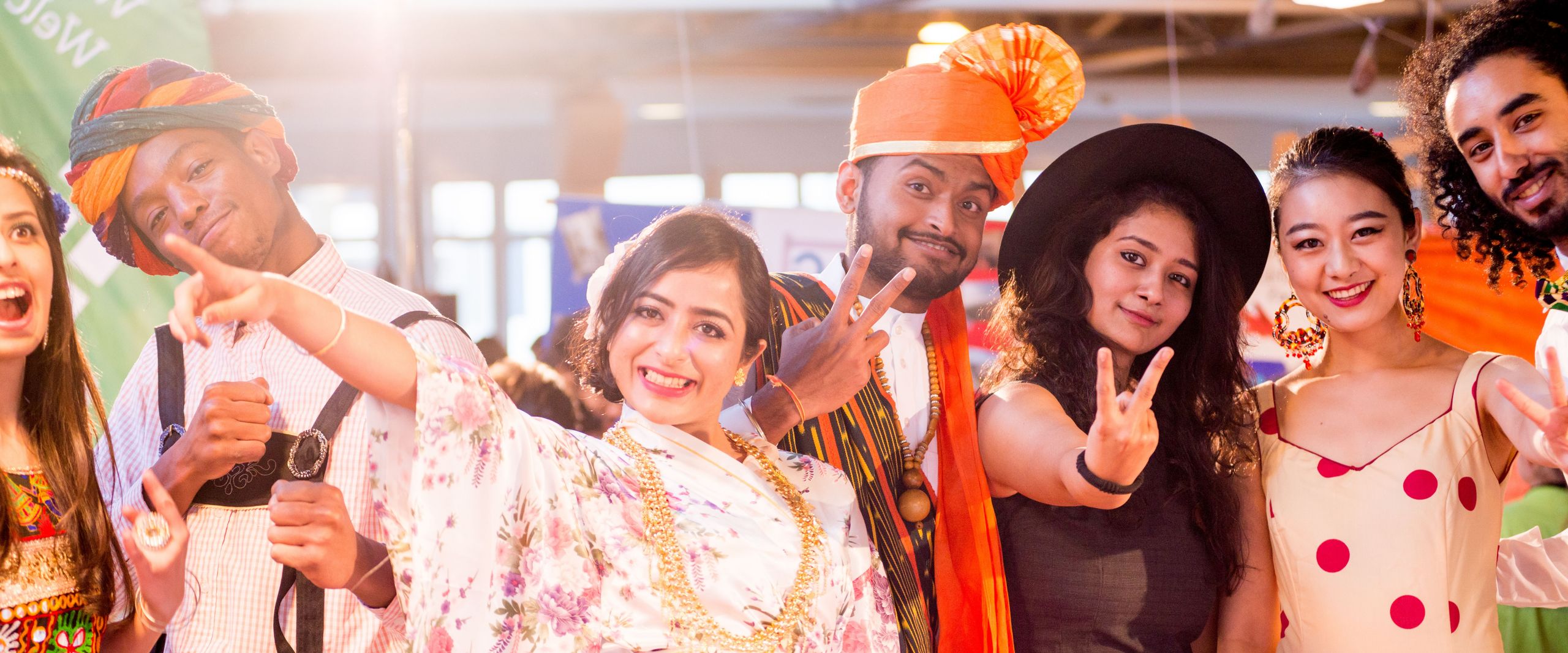 Auf dem Bild sind viele Studierende zu sehen, die traditionelle Kleidung aus unterschiedlichen Kulturen tragen. Alle zusammen befinden sich auf dem International Day 2016 der Hochschule Bremen.