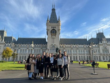 Eine Gruppe Studierender posiert vor einem Gebäude der Alexandru Ioan Cuza Universität in Iași, Rumänien.