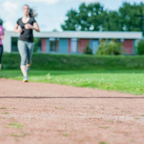 Eine Personengruppe l&auml;uft &uuml;ber Rasen.