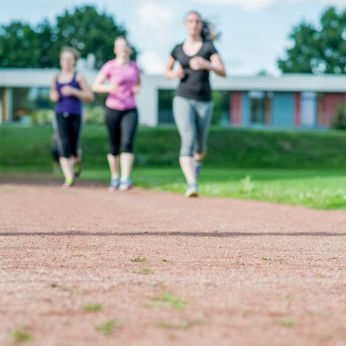 Eine Personengruppe läuft über Rasen.