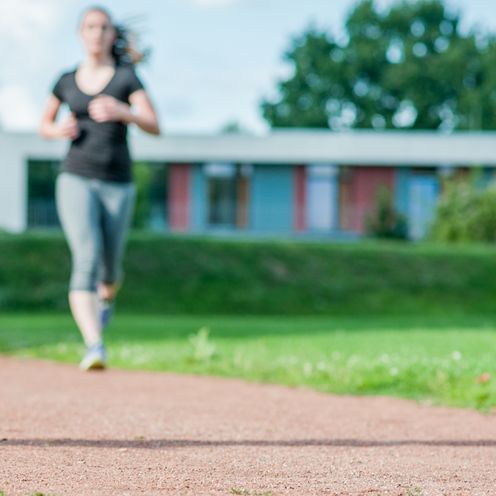 Eine Personengruppe l&auml;uft &uuml;ber Rasen.