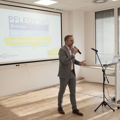 Matthias Z&uuml;ndel begr&uuml;&szlig;t das Publikum beim DBfK Pflegetag am Brill 2025