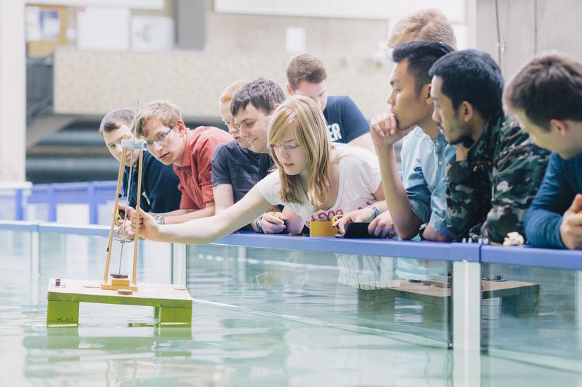 Studierende stehen zusammen vor einem Wasserbecken.