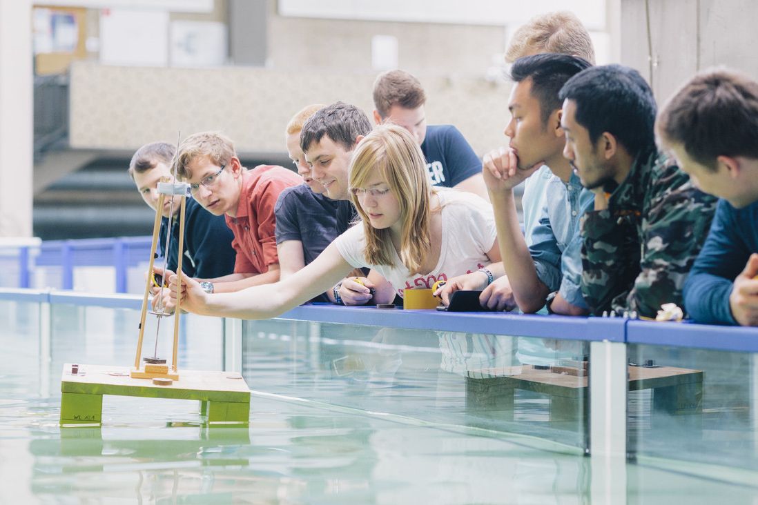 Studierende stehen zusammen vor einem Wasserbecken.