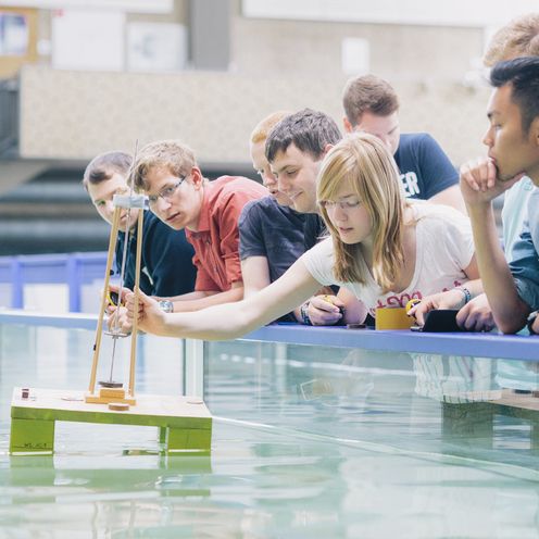Studierende stehen zusammen vor einem Wasserbecken.