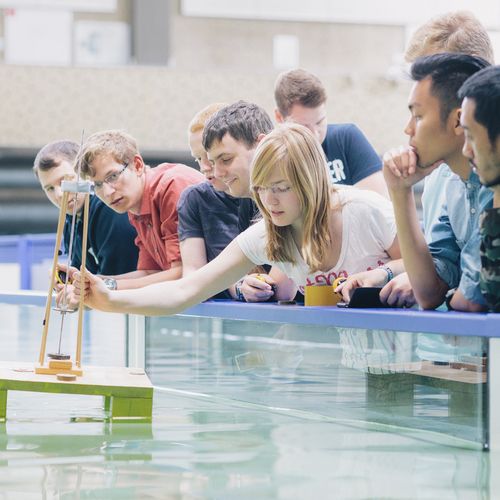 Studierende stehen zusammen vor einem Wasserbecken.