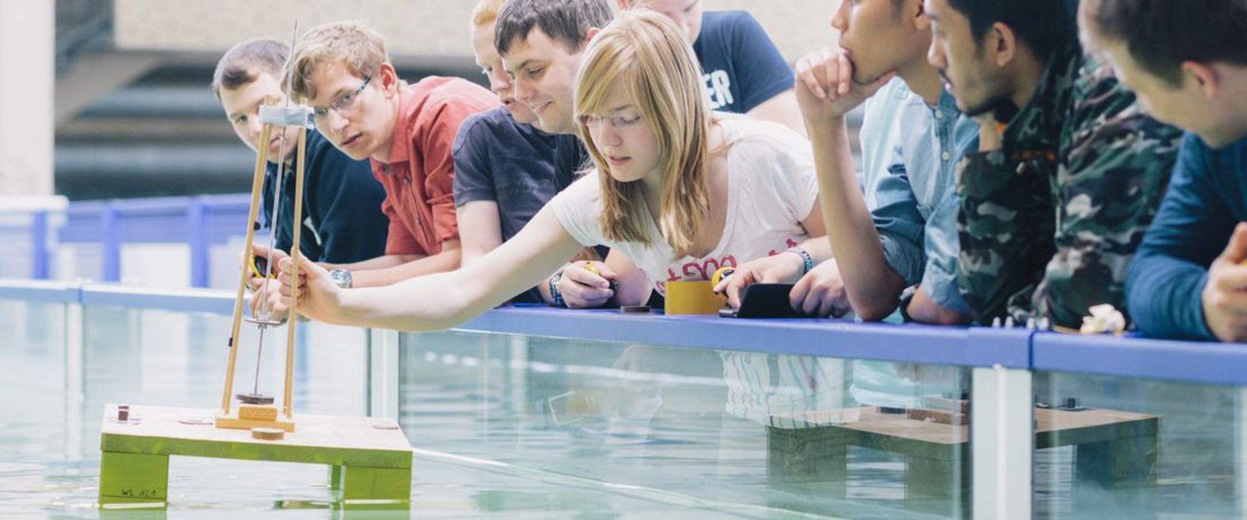 Studierende stehen zusammen vor einem Wasserbecken.