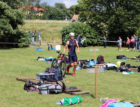 Ein Mitglied der HSB TriRunners schiebt sein Rennrad.