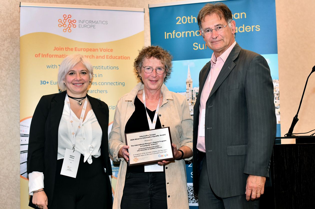 gruppenbild mit zwei Frauen und einem Mann. Die Frau in der Mitte hält eine Urkunde