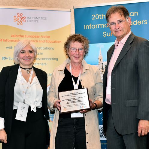 Minerva Award 2024 gruppenbild mit zwei Frauen und einem Mann. Die Frau in der Mitte hält eine Urkunde