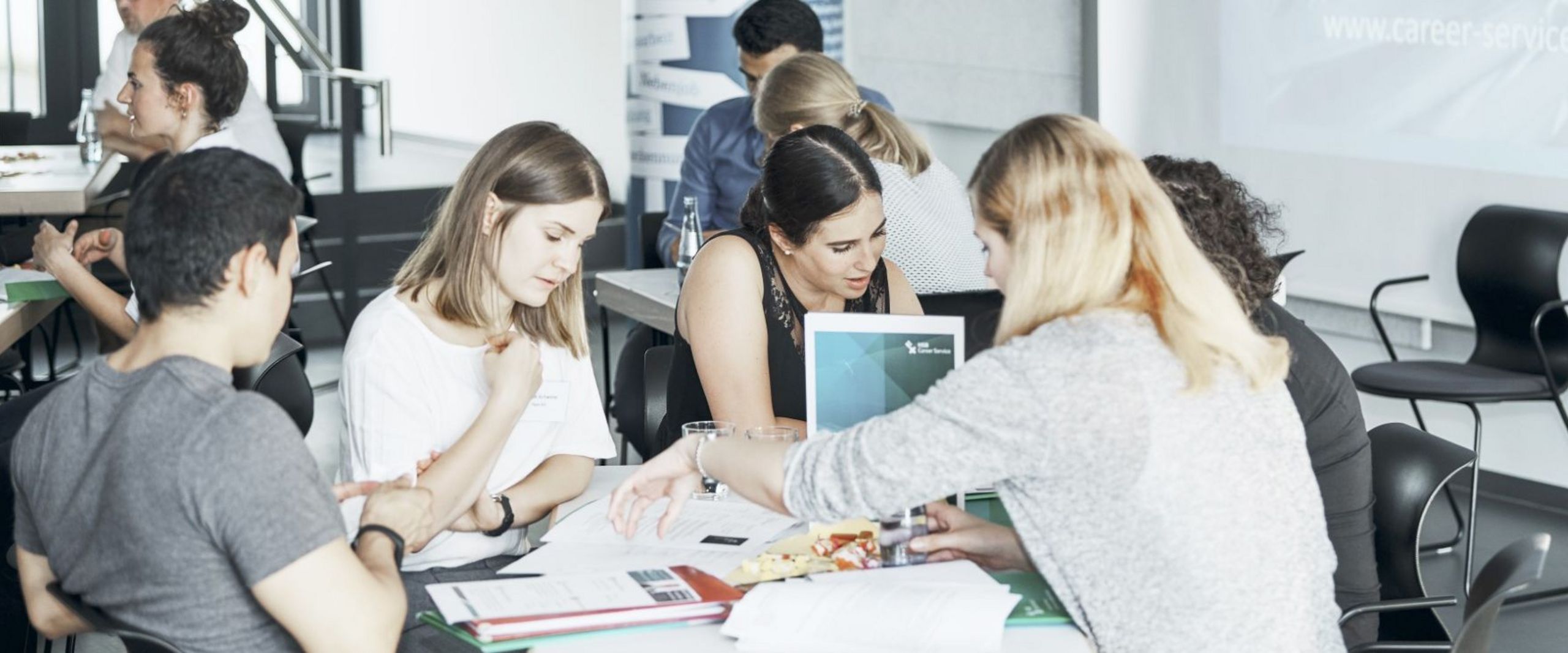 Teilnehmende der "Langen Nacht der Bewerbung" diskutieren an einem Tisch.