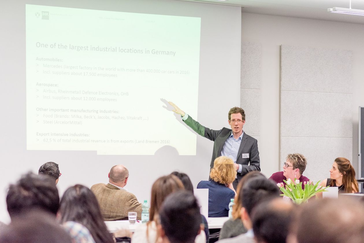 Ein Mann hält einen Vortrag vor Publikum.