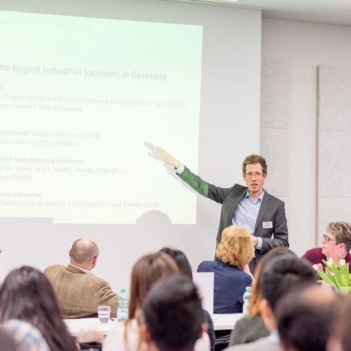 Ein Mann h&auml;lt einen Vortrag vor Publikum.