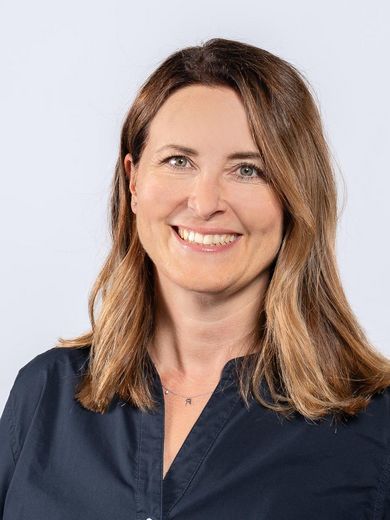 Auf dem Bild ist Anja Weglage zusehen. Sie hat langes braunes Haar und tr&auml;gt eine dunkelblaue Bluse. 