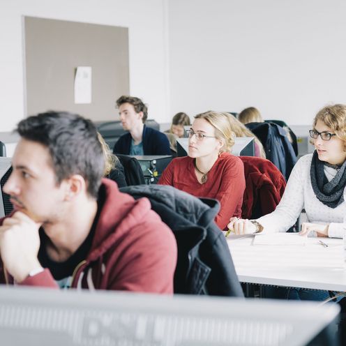 Junge M&auml;nner und Frauen sitzen in einem Seminarraum.