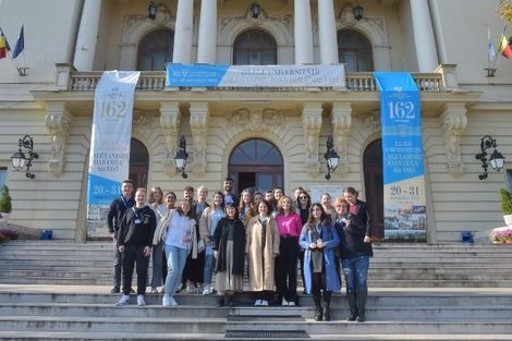 Eine Gruppe Studierender posiert vor einem Gebäude der Alexandru Ioan Cuza Universität in Iași, Rumänien.