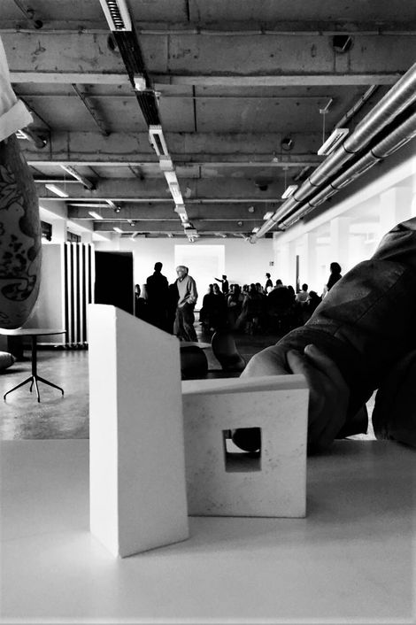 Ein Baumodell auf einem Tisch. Im Hintergrund steht eine Gruppe von Menschen.