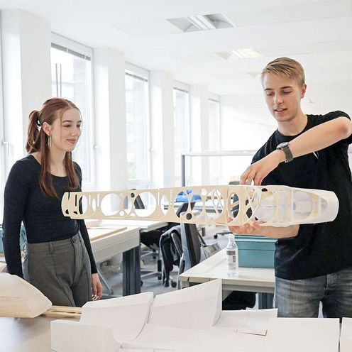 Eine Studentin und ein Student arbeiten an einem Flugzeugmodell 