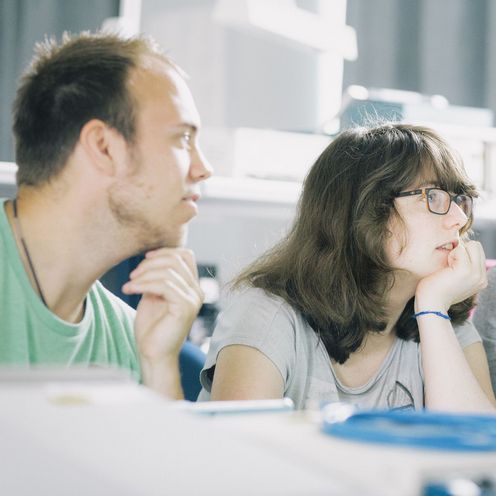 Studierende in einem Labor blicken auf einen Monitor.