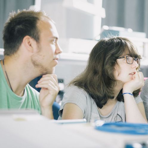 Studierende in einem Labor blicken auf einen Monitor.