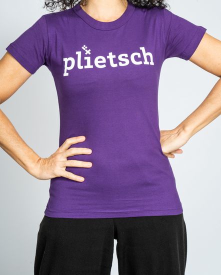 Das Model trägt ein violettes T-Shirt für Damen mit der Aufschrift “plietsch“.