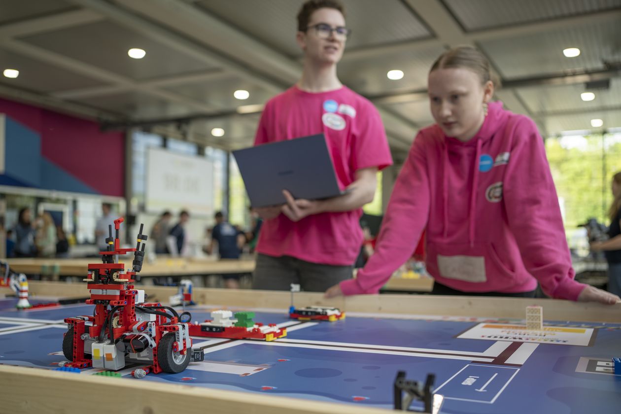 Zwei Personen steuern einen Roboter aus Klemmbausteinen 