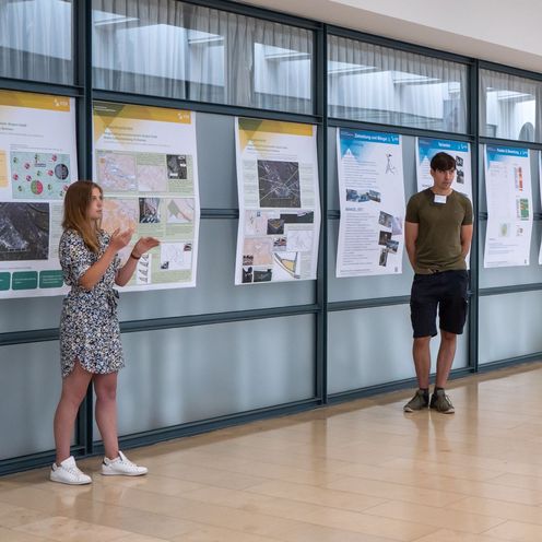 Studierende pr&auml;sentieren dem Publikum ihre Konzepte auf Postern am Bremer Flughafen.