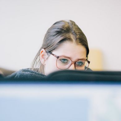 Studierende vor einem Computer im Vorlesungsraum.