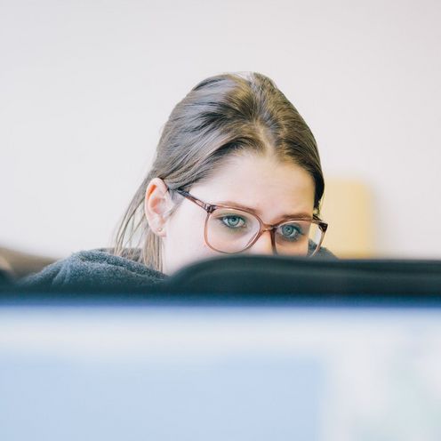 Studierende vor einem Computer im Vorlesungsraum.