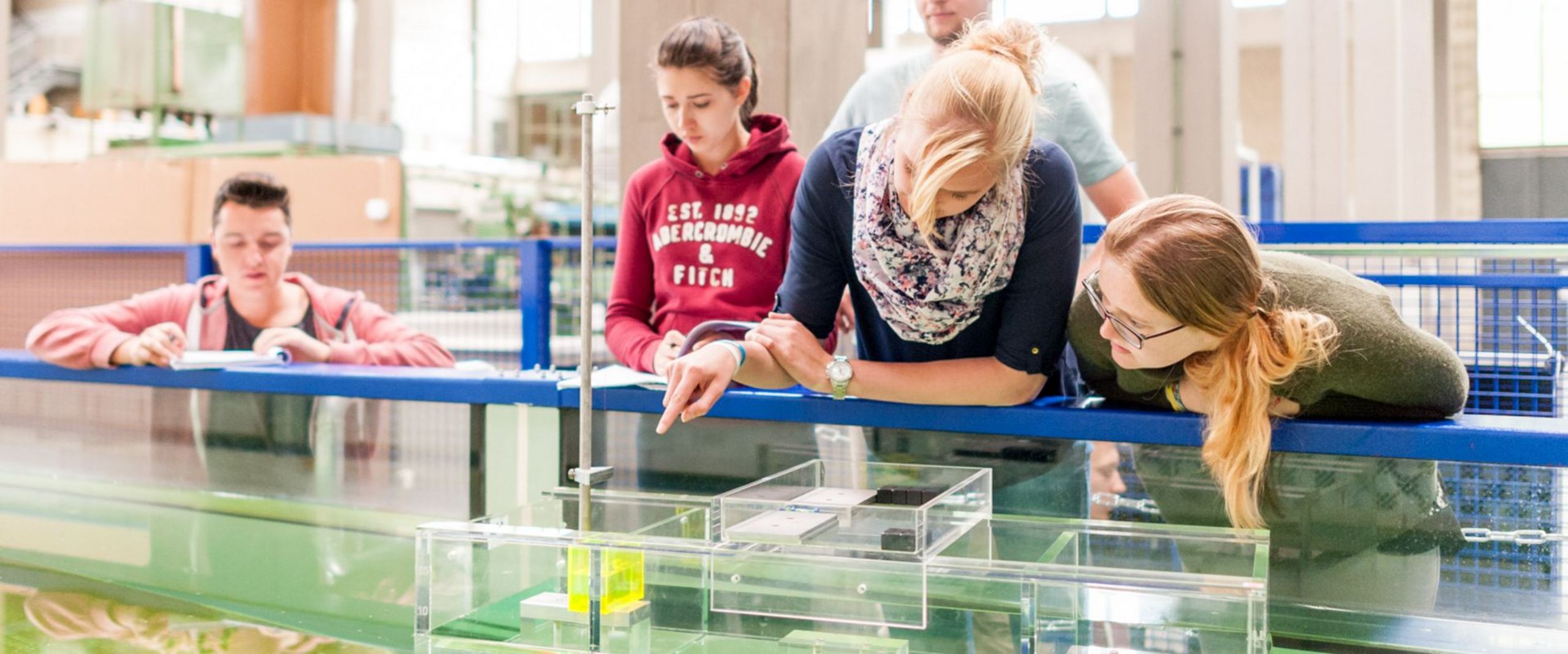 Studierende testen eine schwimmende Konstruktion in einem Wasserbecken.