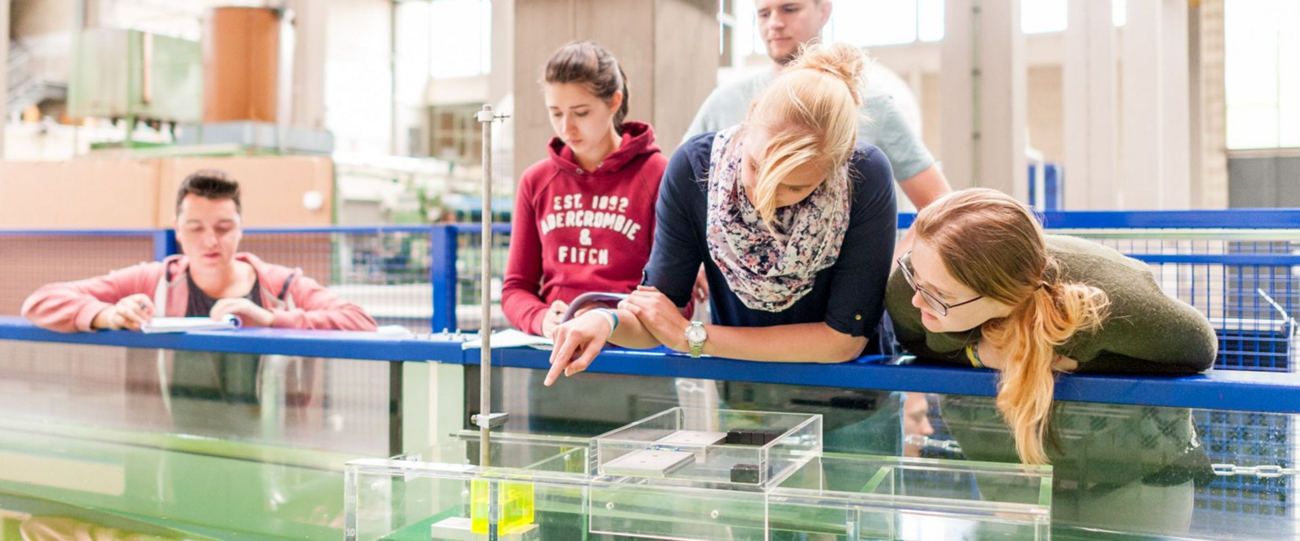 Studierende testen eine schwimmende Konstruktion in einem Wasserbecken.