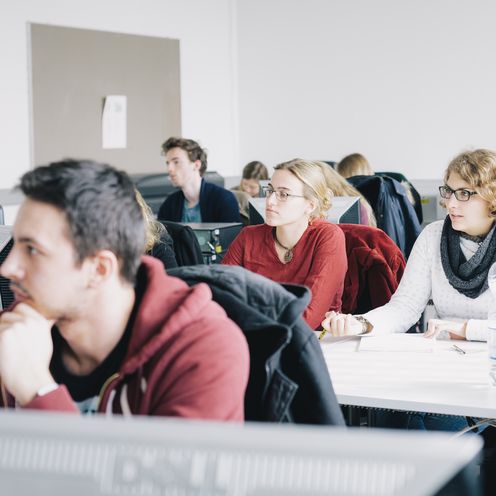 Junge Menschen sitzen in Seminarsaal und arbeiten