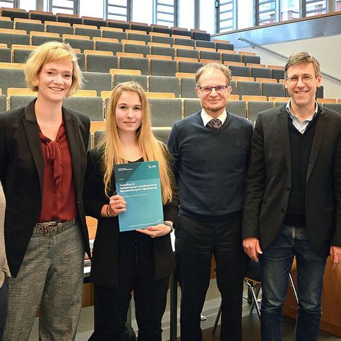 Teilnehmende des Forschungskonvents stehen in einem Hörsaal.