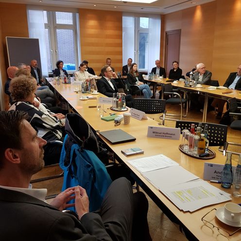 Teilnehmer der Diskussionsrunde im B&ouml;rsensaal der Handelskammer an 2 langen Tischen