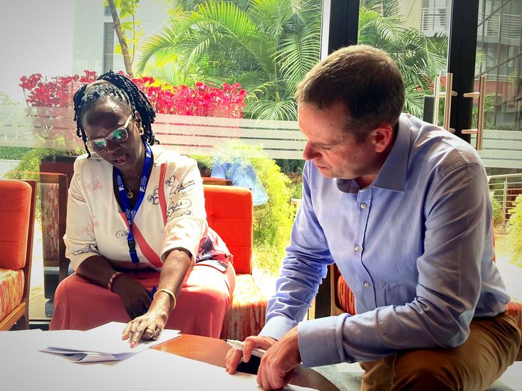 Prof. Dr. Rainer Lisowski sitzt neben Hon. Cicilia Namulen am Tisch.