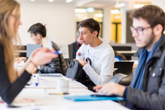 Studierende sitzen in einem Vorlesungsraum.