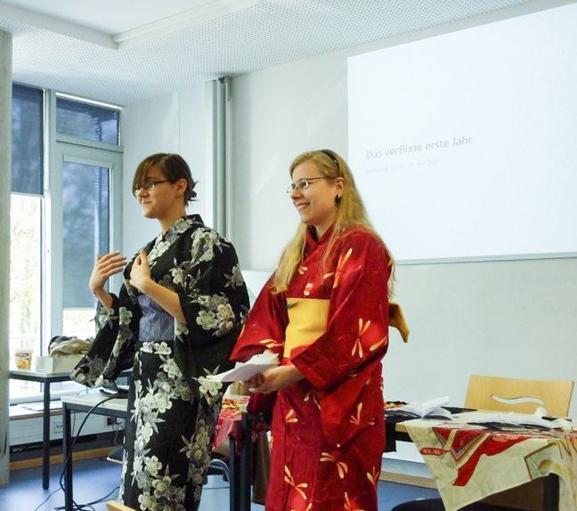 AWS-Studierende Japan Zwei Studentinnen in japanischen Kimonos halten einen Vortrag.