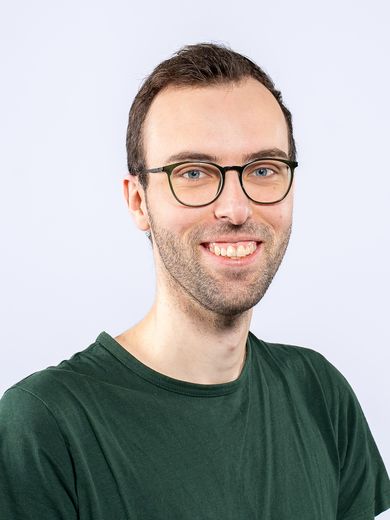 Auf dem Bild ist Niklas B&ouml;lter zusehen. Er hat kurze braune Haare. Er tr&auml;gt eine Brille und ein gr&uuml;nes T-Shirt.