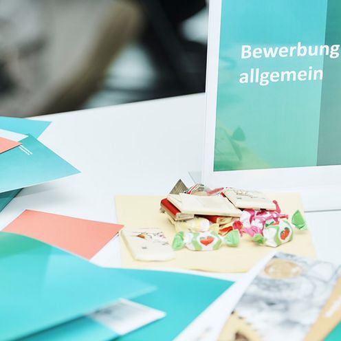 Bewerbungsmappen liegen auf einem Tisch.